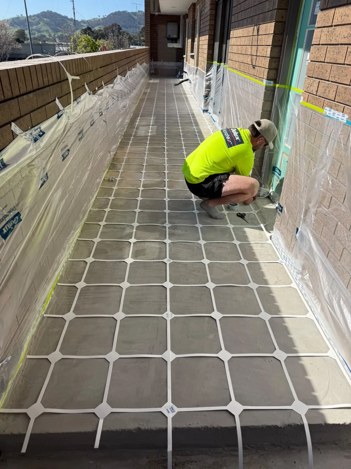 Laying a tile stencil on a side path before the spray pave coat